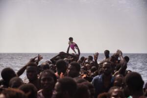 TOPSHOT - Migrants wait to be rescued by members of Proactiva Open Arms NGO in the Mediterranean Sea, some 12 nautical miles north of Libya, on October 4, 2016. At least 1,800 migrants were rescued off the Libyan coast, the Italian coastguard announced, adding that similar operations were underway around 15 other overloaded vessels. / AFP / ARIS MESSINIS (Photo credit should read ARIS MESSINIS/AFP/Getty Images)